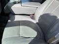 A gray leather seat with visible wear and some stains in the interior of a 2013 Ford F-250 SD