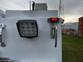 A rear view of a 2016 Ford F-550 featuring a rectangular light with multiple bulbs and a metallic handle next to a small red light