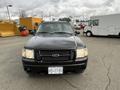 A black 2004 Ford Explorer Sport Trac facing forward with visible headlights and a grill featuring the Ford logo