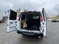 A white 2012 Chevrolet Express van with its rear doors open revealing an empty interior