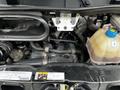 A 2021 RAM Promaster engine compartment showcasing various engine components including hoses and a coolant reservoir