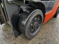 A close-up of the rear wheel of a 2017 Toyota 8FCGCU25 forklift with a sturdy black tire and metal rim