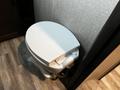A white toilet with a closed lid inside a recreational vehicle bathroom