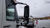 A 2012 International 7400 truck with a large side mirror and visible branding on the door