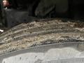 Close-up of a worn tire with visible tread patterns and dirt on its surface