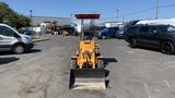 A yellow 2024 Traner TR45 heavy machinery with a front loader attachment facing forward on a paved surface