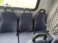 Three blue upholstered seats with safety belts in a vehicle interior