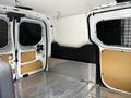 Interior view of a 2016 Ford Transit Connect showing the cargo area with metal flooring and mesh-grilled doors