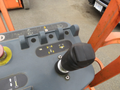 Control panel of a 2009 JLG E300AJP aerial lift with joystick and various function symbols displayed