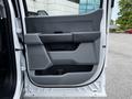 The interior door panel of a 2024 Ford F-550 featuring a sleek design with gray trim and a storage compartment