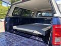 The image shows the open bed of a 2015 Ford F-150 with a flat storage platform installed inside the truck bed