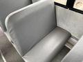 A grey bus seat with a smooth surface and a slightly curved backrest designed for passenger comfort