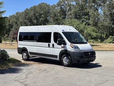 A white 2016 RAM Promaster van parked at an angle with windows along the side and a black front grille