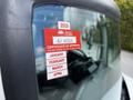A close-up view of a 2020 Hino 338 with a certification sticker on the windshield displaying approval details and expiration dates for January to April