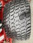 Close-up of a rugged tire with a deep tread pattern designed for traction on various surfaces