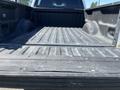 A view of the bed of a 2014 Ford F-150 showing a textured surface with metal ridges and slight wear marks