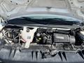 Engine compartment of a 2013 Chevrolet Express showing the engine assembly and various components such as the battery and coolant reservoir