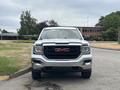 A 2016 GMC Sierra 1500 pickup truck is facing forward with a chrome grille and red GMC emblem prominently displayed