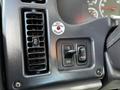 Close-up of the control panel of a 2012 Freightliner M2 112 featuring buttons for air conditioning and cruise control along with a parking brake indicator