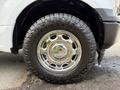 A close-up of a chrome wheel rim with a rugged tire on a 2018 Ford F-150 showcasing its shiny surface and tread pattern