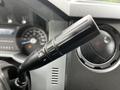 Close-up of the control stalk of a 2011 Ford F-550 featuring a black handle with plus and minus symbols for adjustment