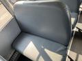 A blue-gray seat inside a school bus with a smooth leather finish and a rounded backrest
