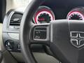 Close-up of the steering wheel and dashboard controls of a 2011 Dodge Grand Caravan featuring buttons for step and reset