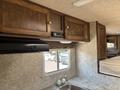 Interior of a 2018 Westland Travelaire featuring wooden cabinets a sink and a window with closed blinds