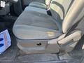 Close-up of the driver's side seat in a 2015 Ford F-450 SD showing a tear in the fabric on the left side and a dark rubber floor mat underneath