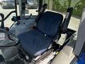 Interior of a 2018 New Holland Boomer 45 tractor featuring a blue seat with a patterned design and a steering wheel visible on the left side