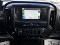 The interior dashboard of a 2017 GMC Sierra 1500 featuring a touchscreen display with navigation and control buttons for climate and audio settings