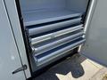 A close-up view of the storage compartment of a 2023 Ford F-550 showing several metal drawers with smooth sliding rails