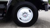 Close-up of a white rim with a central red hubcap mounted on a large black tire from a 2012 International 7400 truck