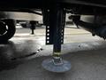 A stabilizing jack of a 2021 Grand Design Recreational 311BHS trailer with a circular base and adjustable height mechanism