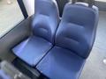 A pair of blue fabric seats designed for a vehicle with a textured surface and padded sections