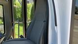 A gray driver's seat from a 2011 Chevrolet Express van with a textured fabric design