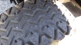 Close-up of a rugged tire with a deep, zigzag tread pattern designed for off-road vehicles like the 2016 Polaris Ranger 570 Crew