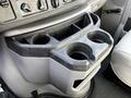 Close-up of a cup holder console in a 2013 Ford Econoline featuring multiple cup holders and storage space