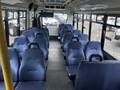 Interior view of a 2017 Chevrolet Express bus showing rows of blue upholstered seats and a spacious aisle