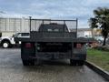 A black 2017 GMC Sierra 3500HD flatbed truck viewed from the rear with a metal rack and tail lights visible