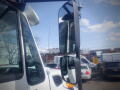 A 2016 International WorkStar 7500 truck featuring a prominent side mirror and a sleek design with a white exterior
