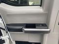 Interior door handle of a 2017 Ford F-550 with a gray finish and a small rectangular window control panel