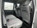 Interior view of the backseat of a 2015 Ford F-550 featuring gray cloth seats with a simple design and seatbelts attached