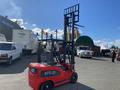 A red 2024 AGT KFE20 forklift with an extended hydraulic lift and fork attachment in a parking area