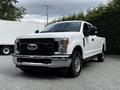 2017 Ford F-250 pickup truck with a white exterior and chrome front grille parked on a driveway