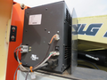 A black electrical control box with various connected wires and connectors mounted on a piece of machinery