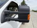 A side mirror of a 2008 Ford F-550 featuring a black exterior and an orange indicator light