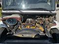 A 2004 Freightliner M2 truck with its hood open, revealing the engine compartment featuring various components like the engine, hoses, and a coolant reservoir