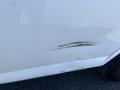 A white 2013 Chevrolet Express with visible scratches and dents on the side panel