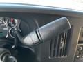 Close-up of the gear shift lever in a 2019 Chevrolet Express with buttons for adjusting gears and indicators on a dashboard